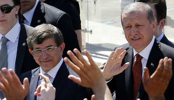 Turkey's Prime Minister Tayyip Erdogan and Foreign Minister Ahmet Davutoglu greet their supporters as they leave Friday prayers in Ankara